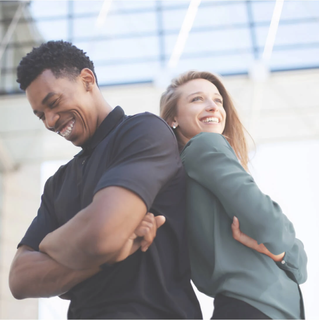 Zwei Personen stehen Schulter an Schulter vor einem Gebäude